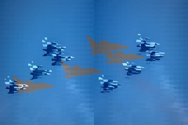 fyra stridsflygplan mot blå himmel