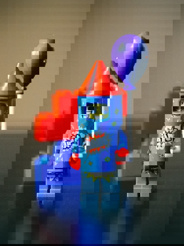 En liten legogubbe med en ballong i lego