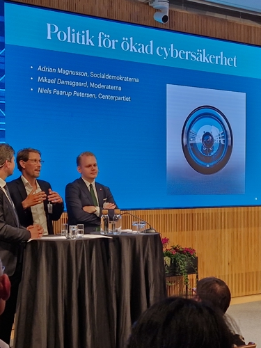 Politikerpanel på scen på IVA mot bakgrundsbild Politik för ökad cybersäkerhet
