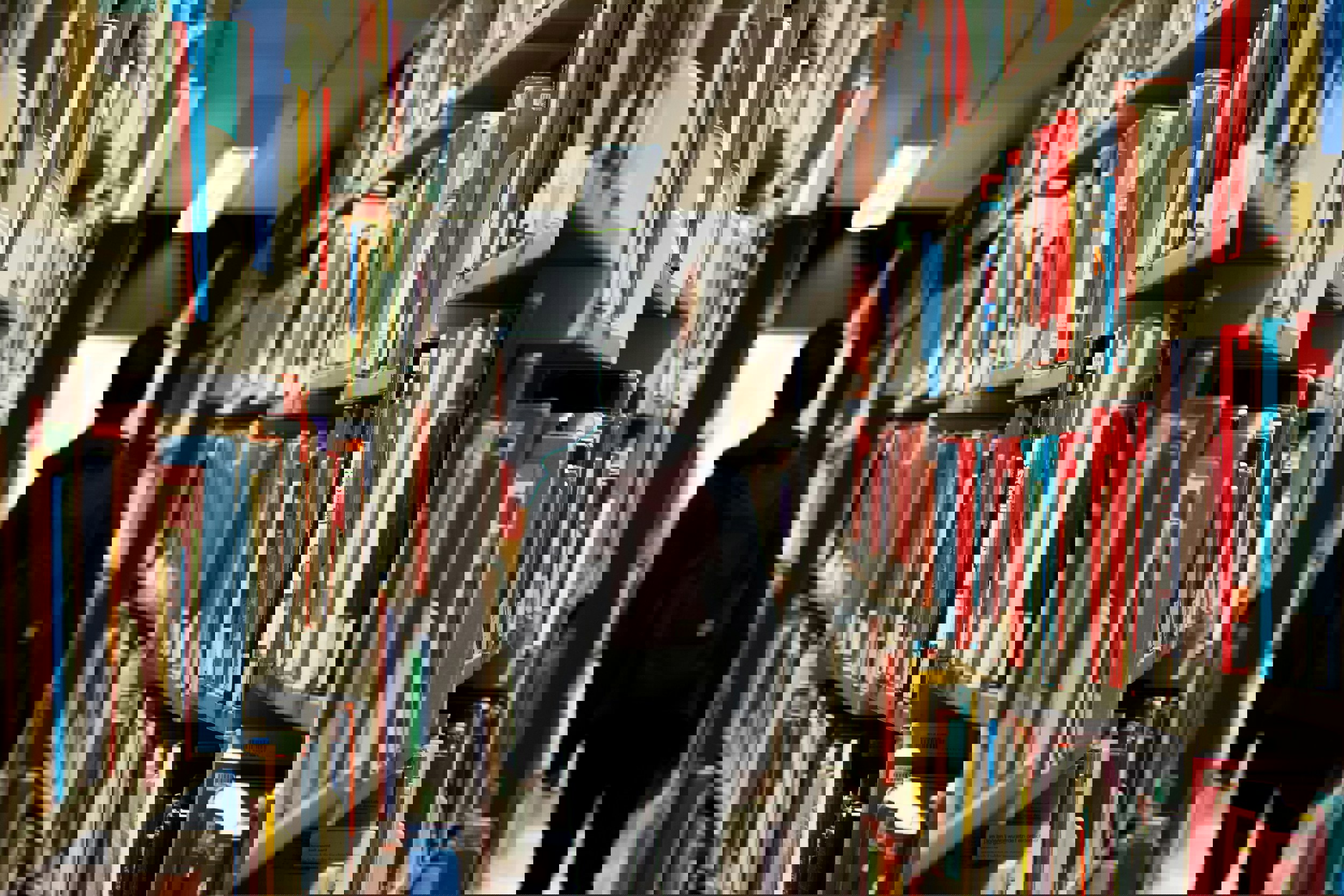 Person med ryggsäck mellan bokhyllor