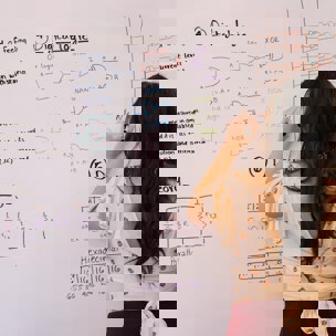Ung person som skriver på en white board
