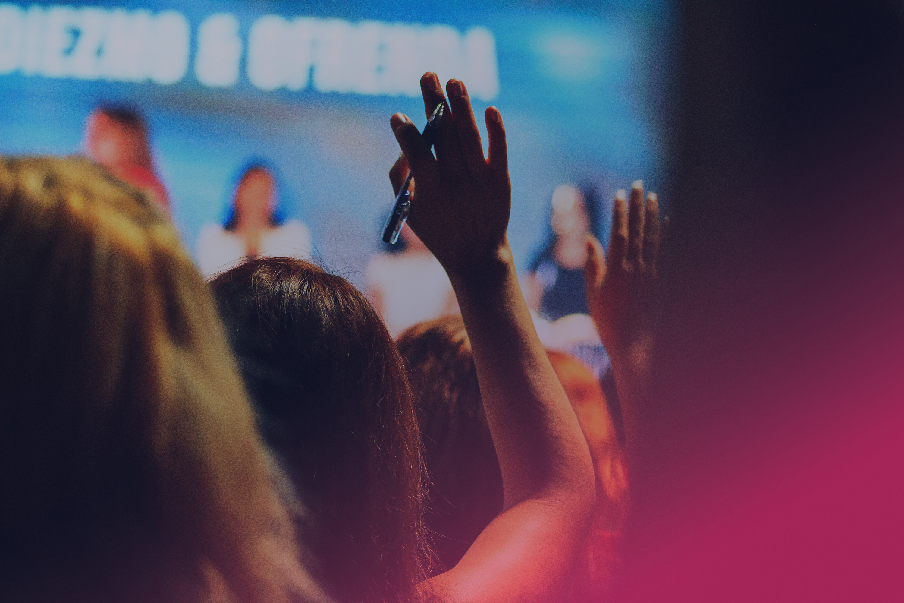 Person i publik räcker upp handen. 