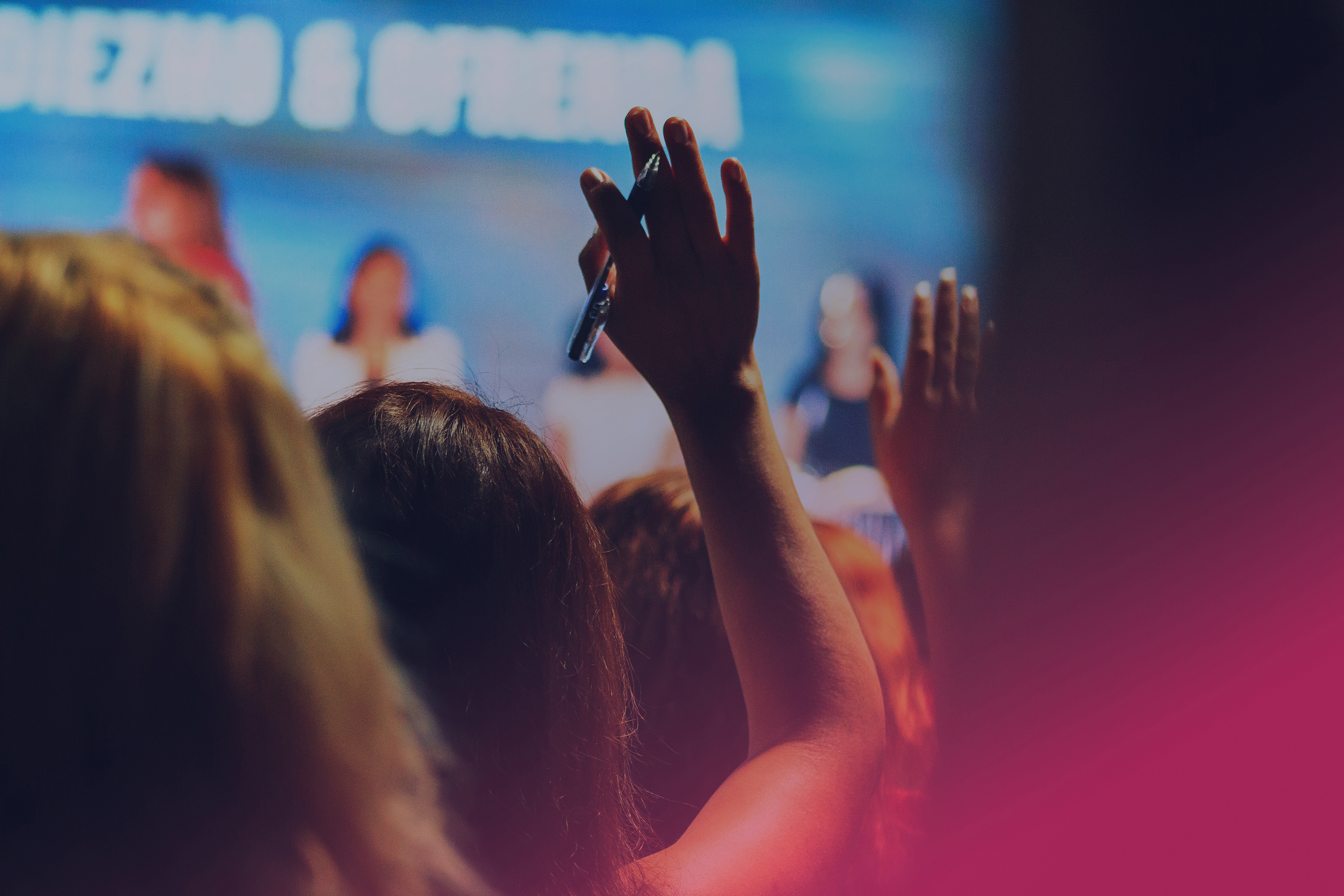 Person i publik räcker upp handen. 