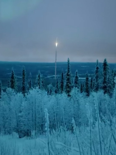 Satellite shooting up from a wintry forest landscape