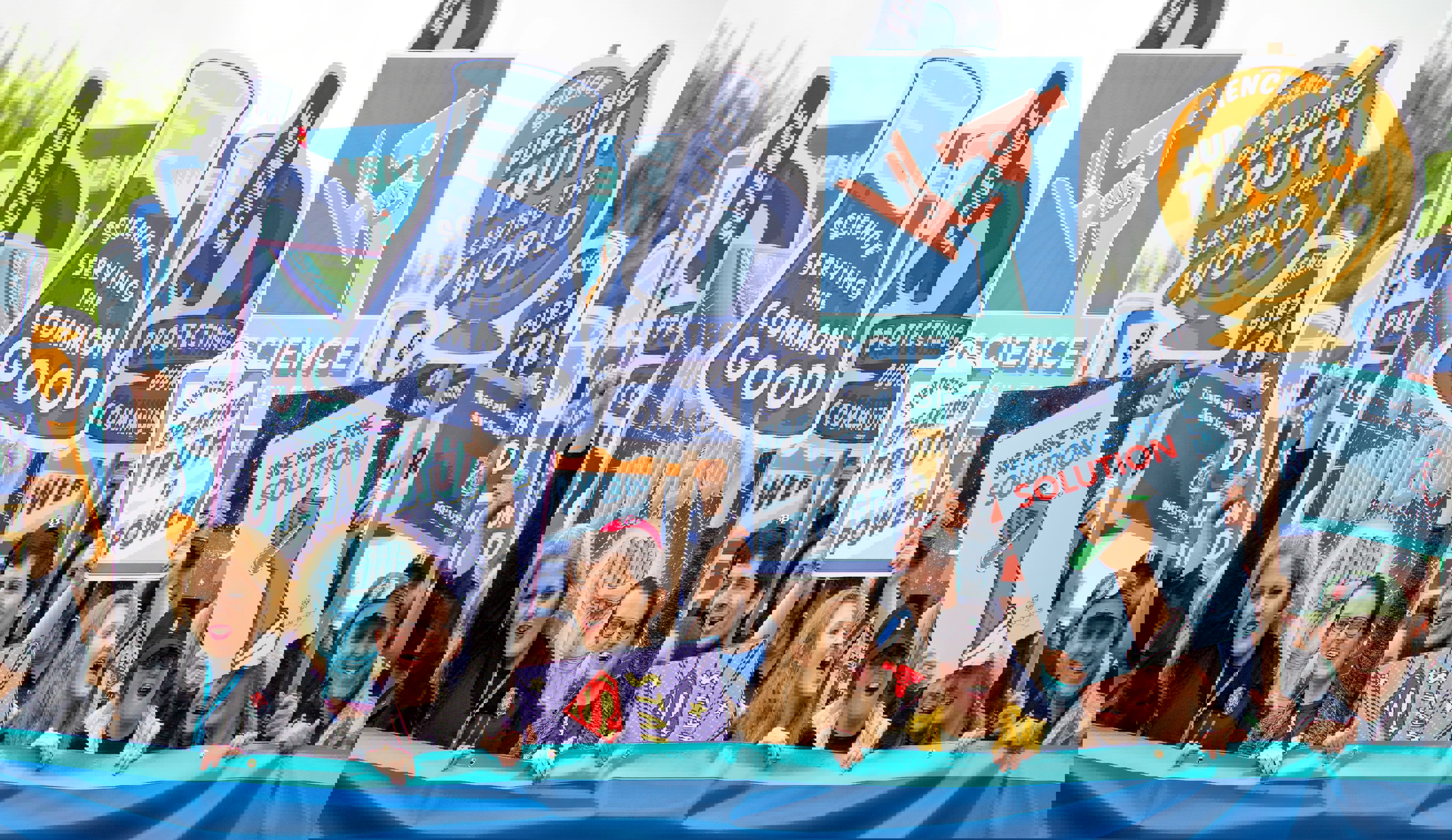 people holding signs praising science