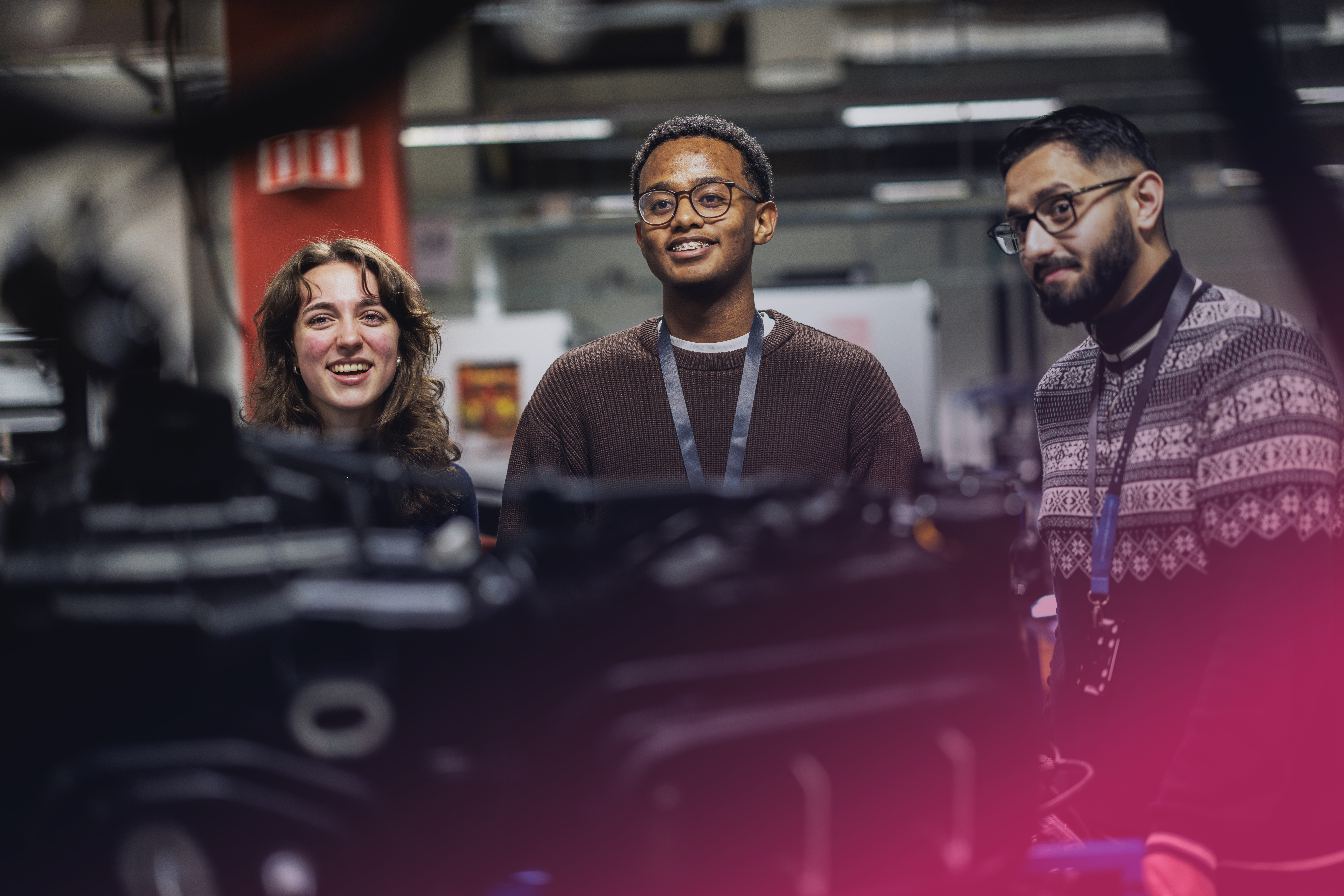 Tre personer som hoppar mot rosa himmel